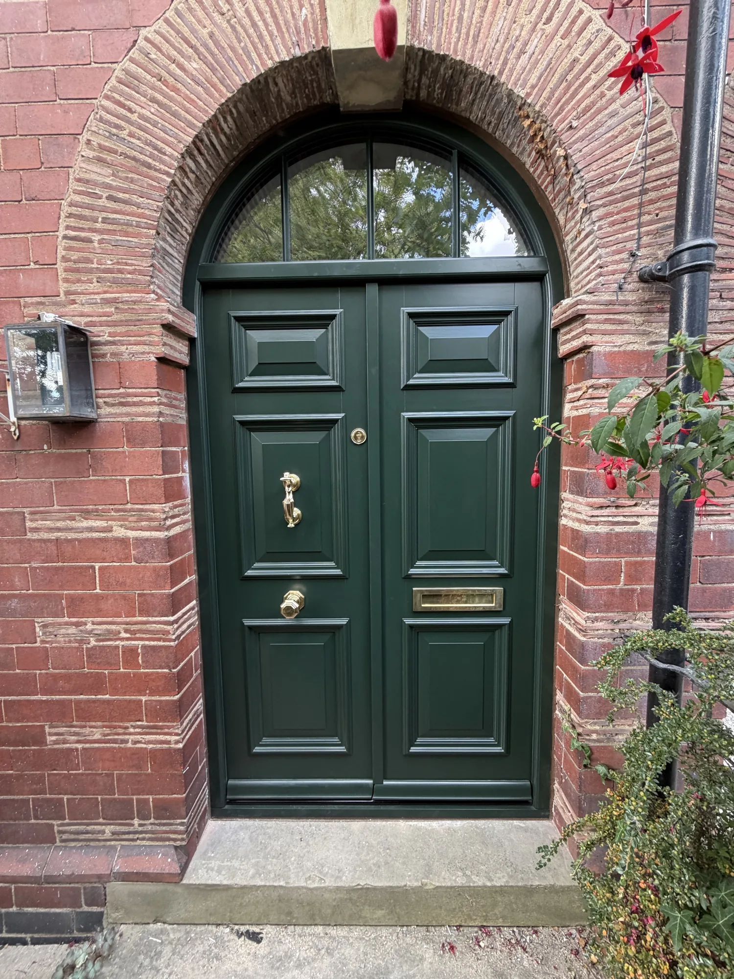 Victorian arched double front door in Fulford, York — Accoya timber, deep green paint, brass hardware. Handcrafted timber by Bailey Hague Joinery, Yorkshire.
