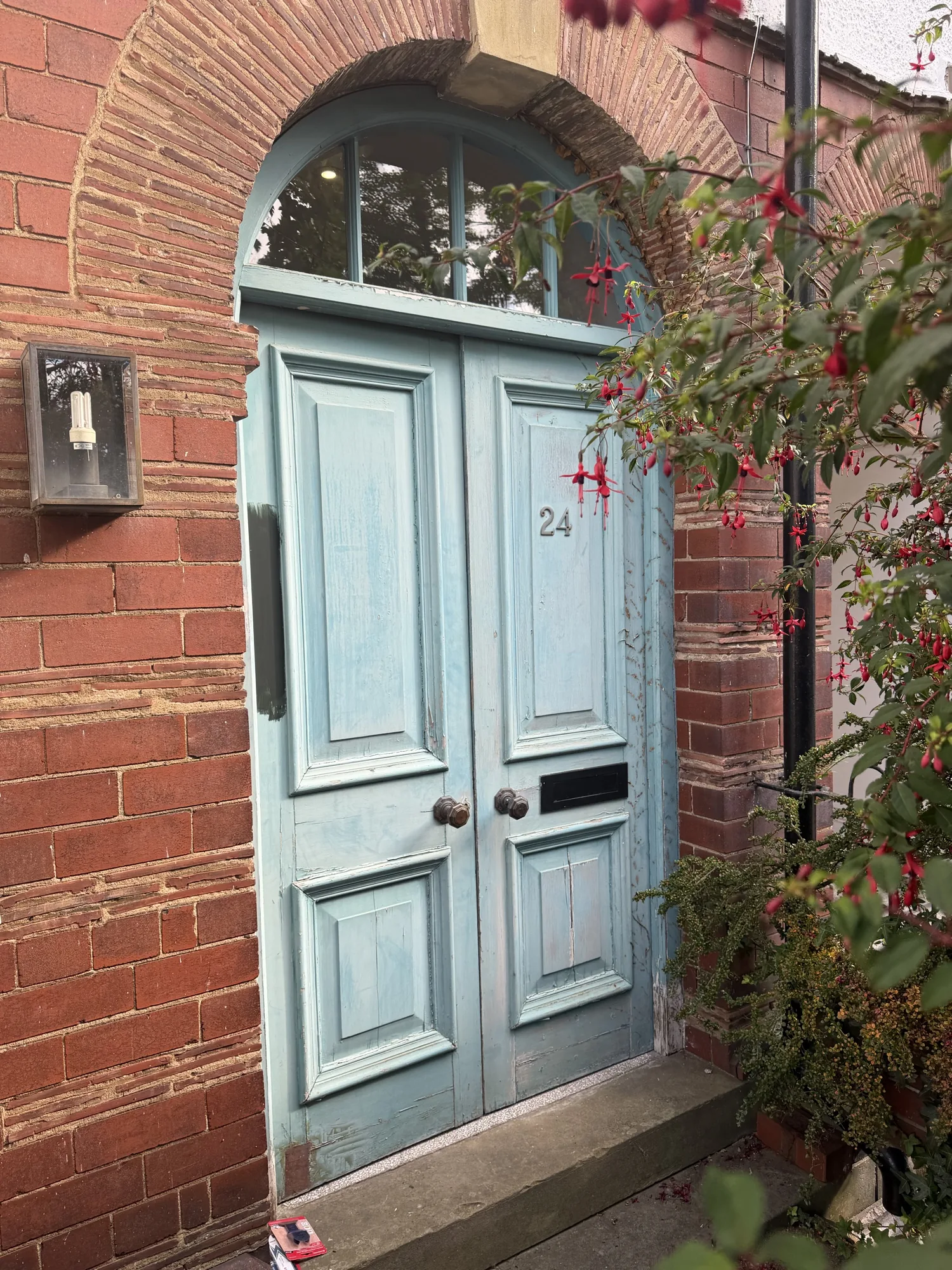 The original faded blue Victorian double front door in Fulford, York — peeling paintwork, weathered joints and a permanent draught through into the hallway