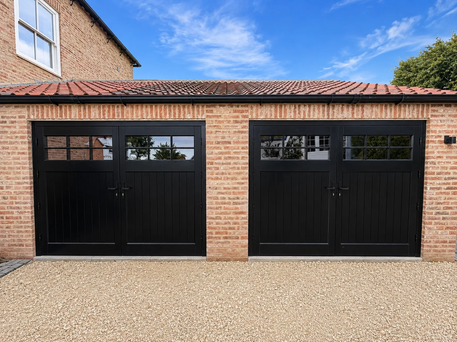 Two pairs of black Accoya garage doors with 6-pane top lights, fitted near York
