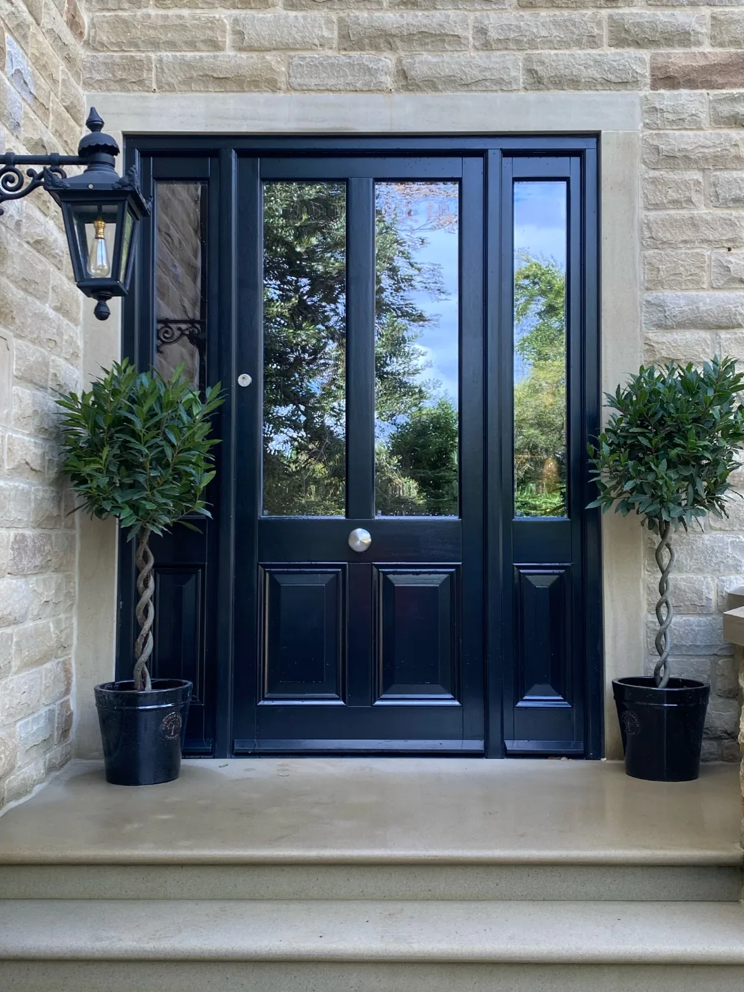 Black gloss half-glazed heritage front door with sidelights and bay topiaries — bespoke Accoya heritage door by Bailey Hague Joinery, Yorkshire.