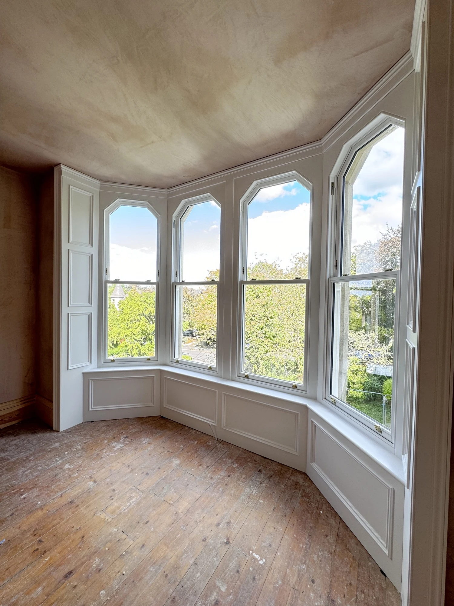Curved upstairs bay of Accoya sash windows with trefoil Gothic-arched heads, sprayed white, Queens Road Harrogate